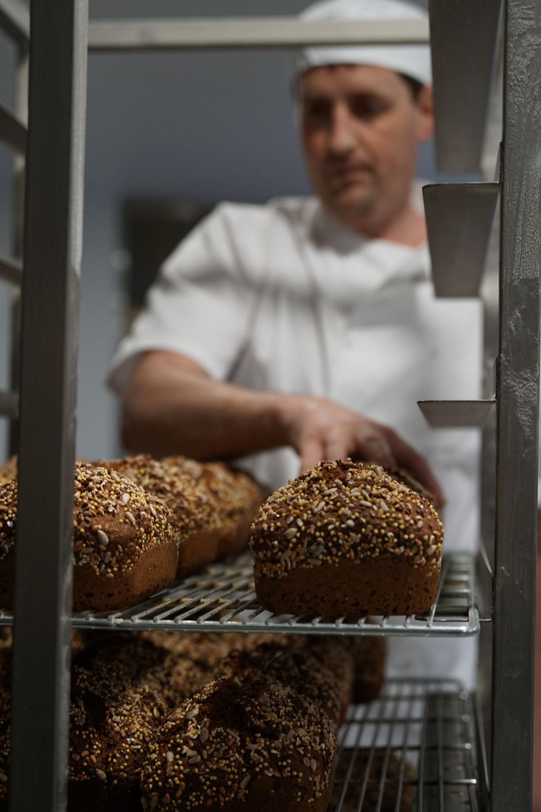 Seeded treacle soda bread loaves cooling on a bakery rack